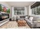 Bright living room featuring plush seating, a modern fireplace, and large windows at 2110 W 67Th Pl, Denver, CO 80221