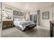 Spacious main bedroom featuring a luxurious upholstered bed, bench seat, and sliding glass doors to the outside at 2110 W 67Th Pl, Denver, CO 80221
