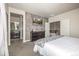 A primary bedroom featuring an accent wall, mounted TV, and ensuite bathroom, offering a private retreat at 2110 W 67Th Pl, Denver, CO 80221