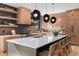 Modern kitchen with light wood cabinets, large island, and dark gray backsplash at 410 S Vine St, Denver, CO 80209