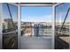 Open French doors reveal a balcony with a city view and a backdrop of distant mountains at 2020 Arapahoe St # 1130, Denver, CO 80205