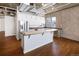 Bright kitchen with a large island, white cabinets, stainless steel appliances, and hardwood floors at 2020 Arapahoe St # 1130, Denver, CO 80205