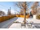 Fenced backyard with patio furniture and winter snow at 4191 S Eliot St, Englewood, CO 80110