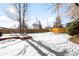 Large backyard with a snow-covered lawn and wooden fence at 4191 S Eliot St, Englewood, CO 80110