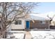 Brick ranch home with a blue door, snowy yard, and mature trees at 4191 S Eliot St, Englewood, CO 80110