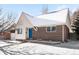 Brick ranch home with a blue door and snowy front yard at 4191 S Eliot St, Englewood, CO 80110