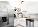 Modern kitchen with white cabinets, stainless steel appliances, and farmhouse sink at 4191 S Eliot St, Englewood, CO 80110