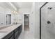Contemporary bathroom features a double vanity, sleek fixtures, and a glass-enclosed shower with marble-look tile at 8894 Yellowcress St, Littleton, CO 80125