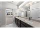 Bright bathroom features dual sinks, modern lighting, and a view into the bedroom and glass enclosed shower at 8894 Yellowcress St, Littleton, CO 80125