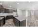Kitchen features a center island, modern appliances, and dark cabinets with white countertops at 8894 Yellowcress St, Littleton, CO 80125