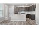 Modern kitchen featuring an island, stainless appliances, dark cabinets and tile backsplash at 8894 Yellowcress St, Littleton, CO 80125