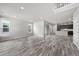Open-concept living room with wood floors, leading to the kitchen with modern appliances at 8894 Yellowcress St, Littleton, CO 80125