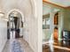 Elegant hallway featuring hardwood floors, arched doorways, and stylish lighting fixtures at 13901 E Saratoga Pl, Aurora, CO 80015