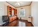 Bright home office with wood floors, built-in shelves, plantation shutters, and a ceiling fan at 13901 E Saratoga Pl, Aurora, CO 80015