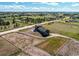 Wide aerial view of gray two-story home, open fields, and neighboring houses in a serene rural setting at 42919 Vista Rdg, Parker, CO 80138
