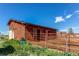 Rustic red barn with a metal roof and enclosed paddock area, perfect for livestock or storage at 42919 Vista Rdg, Parker, CO 80138