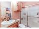 Well-lit bathroom featuring a sink, toilet, and shower with sliding doors at 42919 Vista Rdg, Parker, CO 80138