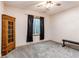 Finished basement bedroom features neutral carpet, window, and antique cabinet at 42919 Vista Rdg, Parker, CO 80138