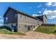 Back view of gray two-story home with basement door, several windows, and a well-maintained backyard at 42919 Vista Rdg, Parker, CO 80138