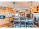 Modern kitchen with wooden cabinets, bar seating, and stainless steel appliances at 42919 Vista Rdg, Parker, CO 80138