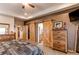 Spacious main bedroom showcases natural light, tray ceiling, and barn doors to the bath and closet at 42919 Vista Rdg, Parker, CO 80138