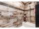 Stylish shower with decorative tiling, shelving, and rainfall shower head at 42919 Vista Rdg, Parker, CO 80138