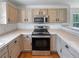 Close-up of kitchen boasting stainless steel appliances, tiled countertops, and light-toned cabinets at 1491 Ophir Rd, Castle Rock, CO 80109