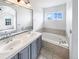 Main bathroom featuring double sinks, a soaking tub, and ample natural light from the window at 1491 Ophir Rd, Castle Rock, CO 80109