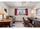 Well-lit bedroom offering two large desks, neutral carpets, and a central window at 7590 E Easter Pl, Centennial, CO 80112