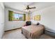 Cozy bedroom features a ceiling fan, neutral carpet, and a window with natural light at 7590 E Easter Pl, Centennial, CO 80112