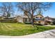Well-maintained two-story home featuring a lush green lawn and mature trees in a suburban setting at 7590 E Easter Pl, Centennial, CO 80112