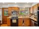 Functional kitchen with wooden cabinets, modern appliances, and a garden window above the sink at 7590 E Easter Pl, Centennial, CO 80112