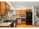 Well-equipped kitchen featuring stainless steel appliances, wooden cabinets, and stylish backsplash at 7590 E Easter Pl, Centennial, CO 80112