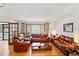 Cozy living room featuring hardwood floors, comfortable leather sofas, and ample natural light at 7590 E Easter Pl, Centennial, CO 80112