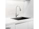 Close-up of the kitchen sink with a modern faucet, quartz counter and white cabinets at 1901 Wazee St # 304, Denver, CO 80202