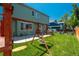 Green fenced-in backyard with a lawn, play structure and mature trees at 20445 Mitchell Pl, Denver, CO 80249