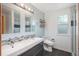 Updated bathroom featuring double sinks, mosaic tile accents, and a window at 20445 Mitchell Pl, Denver, CO 80249