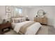 Bright bedroom featuring neutral décor, side tables, lamps, dresser, and art for a serene and stylish aesthetic at 20445 Mitchell Pl, Denver, CO 80249