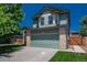 Two-story home featuring a front-facing two car garage, mature landscaping, and a brick facade at 20445 Mitchell Pl, Denver, CO 80249