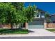 Two-story home featuring a front-facing two car garage, mature landscaping, and a brick facade at 20445 Mitchell Pl, Denver, CO 80249