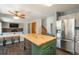 Open-concept kitchen featuring a central island with wooden countertop, stainless steel refrigerator, and bar seating at 20445 Mitchell Pl, Denver, CO 80249
