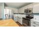 Updated kitchen with stainless steel appliances, white cabinets, and stylish subway tile backsplash at 20445 Mitchell Pl, Denver, CO 80249