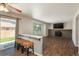 Cozy living room with access to the backyard, featuring wood-look floors, a brick fireplace, and bar seating at 20445 Mitchell Pl, Denver, CO 80249