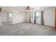 Bright living room featuring plush carpeting, ceiling fan, and windows with patterned curtains at 20445 Mitchell Pl, Denver, CO 80249