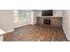 Spacious living room featuring wood-look floors, a brick fireplace, and a bright window overlooking the backyard at 20445 Mitchell Pl, Denver, CO 80249