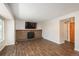Open living room with wood-look floors, a brick fireplace with tv, and neutral-colored walls at 20445 Mitchell Pl, Denver, CO 80249