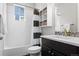 Bathroom featuring tub and shower combo, white vanity with dark cabinet and white shelves at 1867 W 137Th Ln, Broomfield, CO 80023