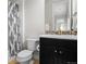 Bathroom featuring black vanity with tiled backsplash, toilet and shower with patterned curtain at 1867 W 137Th Ln, Broomfield, CO 80023