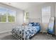 Bright bedroom with a white metal bed frame, blue patterned bedding and a full length mirror at 1867 W 137Th Ln, Broomfield, CO 80023
