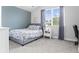 Bedroom with blue accent wall, gray bed frame, white nightstand and a large window at 1867 W 137Th Ln, Broomfield, CO 80023